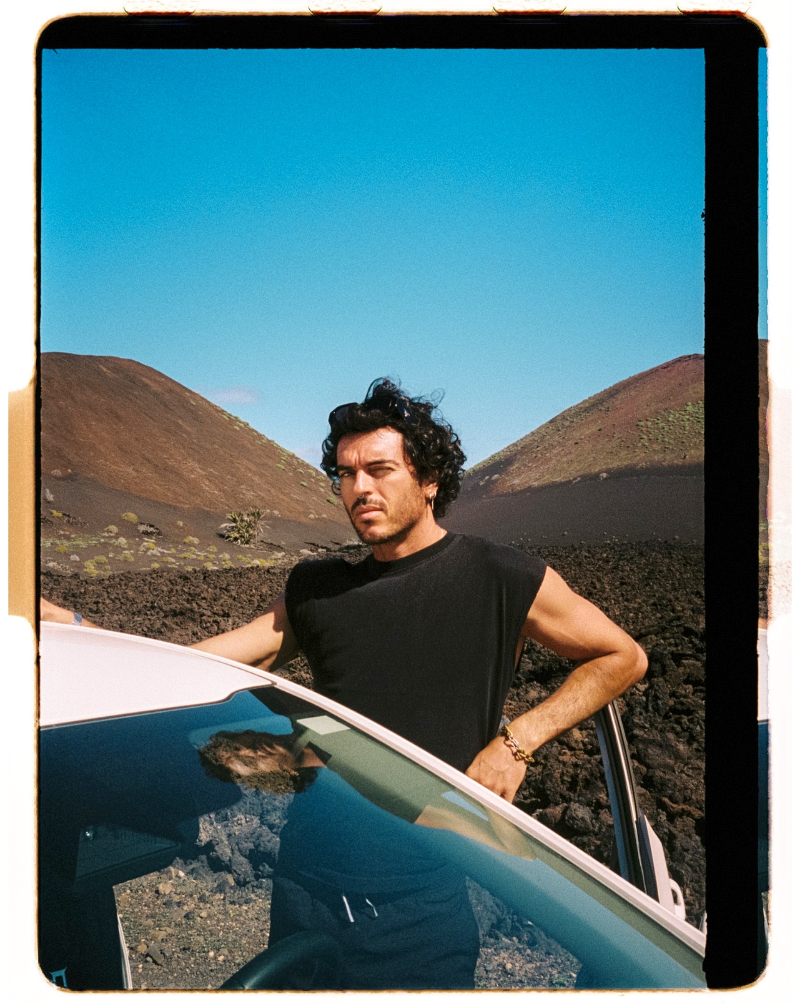Dani Gomiz in a volcanic landscape beside a car